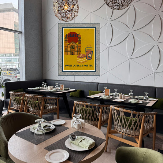Budapest Sweet Layers & Hot Tea art poster displayed in a modern, light-filled bistro interior with wooden furniture and a cozy café atmosphere