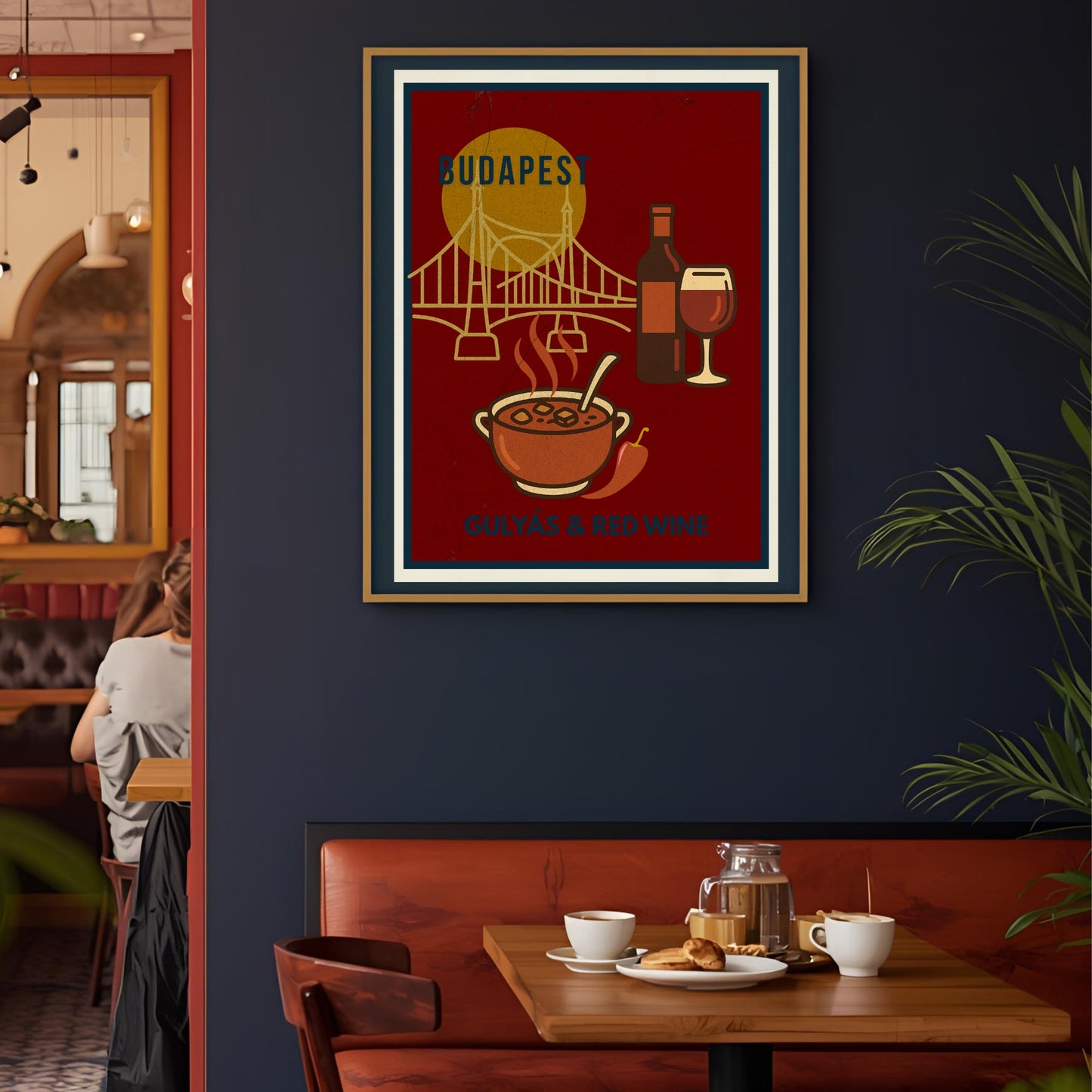 Framed Budapest wall art poster featuring Hungarian goulash and red wine, displayed on a café wall with warm, moody lighting, reflecting urban gastro culture and slow living.